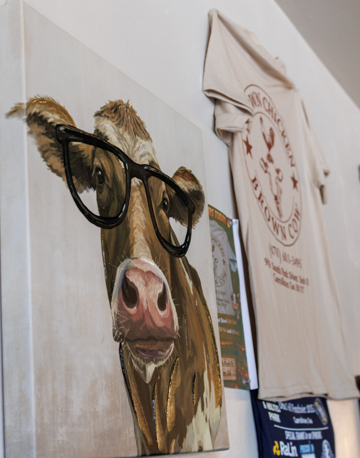 The beloved cow painting wearing real glasses, hanging by the door at Brown Chicken Brown Cow