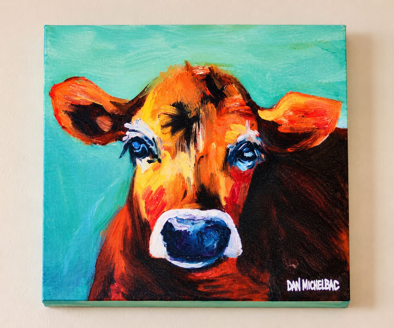 Colorful painted cow portrait hanging in Brown Chicken Brown Cow